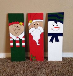 three wooden christmas decorations are sitting on the floor in front of a wall and carpet