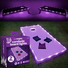 two light up bean bag tossers in the grass with purple and white lights on them