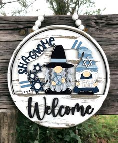 a welcome sign hanging from the side of a wooden fence with an image of two gnomes