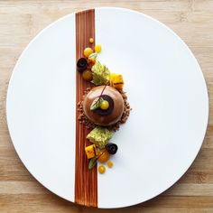 a white plate topped with a dessert on top of a wooden table