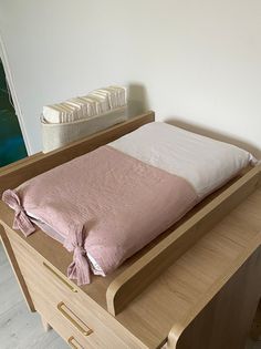 a baby crib with a pink and white blanket on it's top shelf