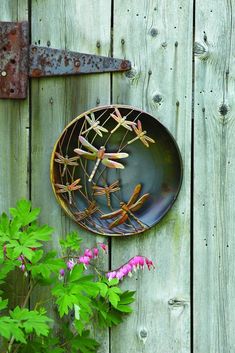 an instagram photo with a plate and flowers on the wall next to wooden fence