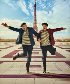 two men are jumping in front of the eiffel tower