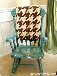 a green rocking chair with a quilt on it