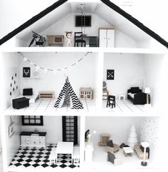 a white doll house with black and white furniture