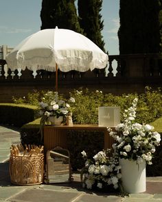 an umbrella sitting on top of a table next to flowers