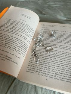 an open book with silver charms on it