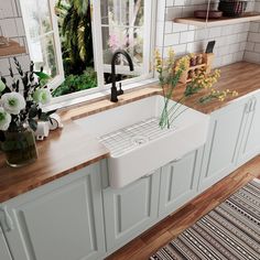 a white kitchen sink sitting on top of a wooden counter