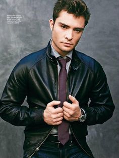 a young man in a leather jacket and tie poses for a magazine cover shot with his hands on his hips