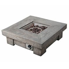 a square concrete fire pit sitting on top of a wooden table