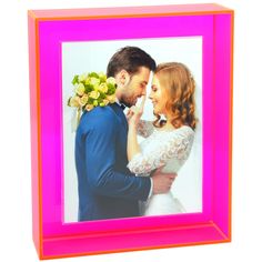 a man and woman standing next to each other in front of a pink photo frame