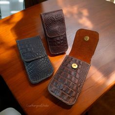 two leather cases sitting on top of a wooden table