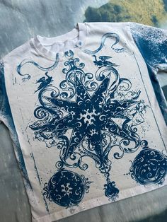 a blue and white t - shirt with an intricate design on it