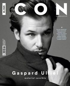 a man in a black suit is on the cover of a magazine with his finger under his chin