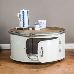 a white coffee table with an old fashioned microwave oven on it's side shelf