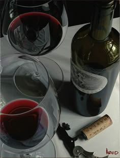 two wine glasses and a bottle on a table