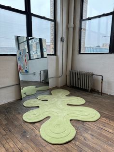 a large mirror sitting on top of a wooden floor next to a radiator