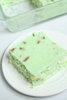 a piece of cake sitting on top of a white plate next to a plastic container