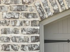 an open garage door on the side of a brick building