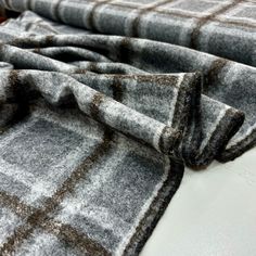 a close up of a blanket on a bed with brown and white checkered fabric