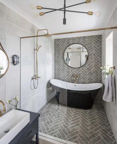 a bathroom with a black and white bathtub next to a large mirror on the wall