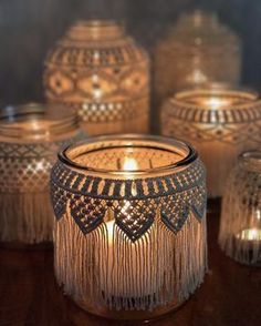 several glass jars with candles in them on a table