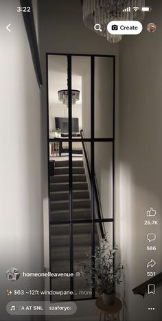 an open door leading up to a stairway with a chandelier hanging from the ceiling