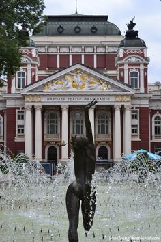 a fountain in front of a large building with lots of water spouting from it