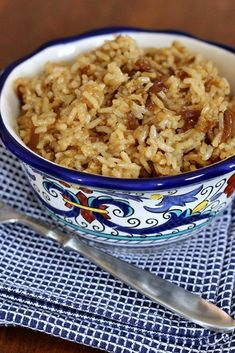 a bowl filled with rice and raisins on top of a blue and white napkin