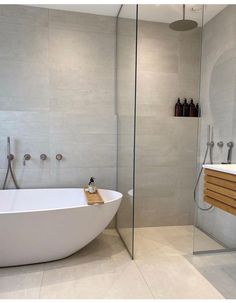 a white bath tub sitting next to a walk in shower