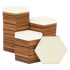 several stacks of wooden coasters stacked on top of each other, with one white hexagon in the middle