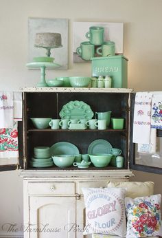 a cabinet filled with green dishes and cups