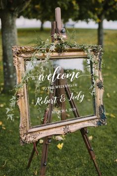 an easel with greenery on it and a sign that says welcome to the wedding of robert & mary