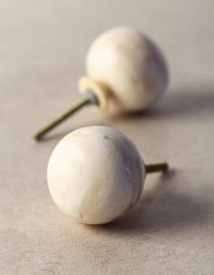 two white knobs are sitting on the floor next to each other, one is turned upside down