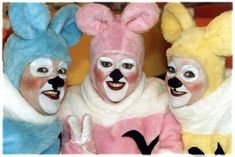 three people in bunny costumes standing next to each other with their faces painted like rabbits