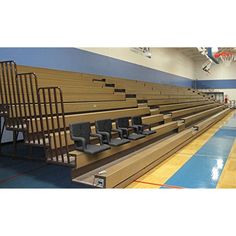 empty bleachers in a gym with seats on the side and blue flooring