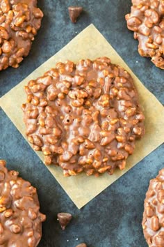 chocolate cookies with peanut butter on top are arranged on a piece of parchment paper and placed next to each other