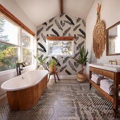 a bathroom with a bathtub, sink and large mirror on the wall above it