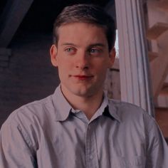 a man standing in front of a pillar with his hands on his hips and looking at the camera