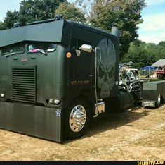 an army green truck with a skull painted on it's side parked in a field