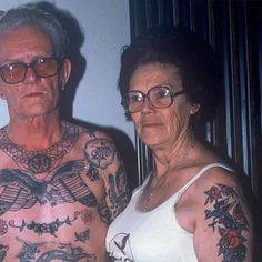 an older man and woman with tattoos on their bodies