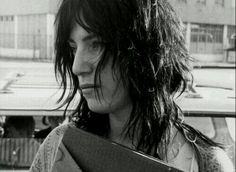 a black and white photo of a woman with long hair holding a book in her hands