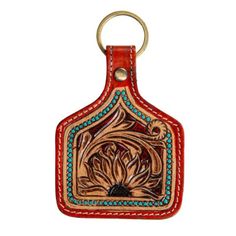 a red leather key chain with a flower design on the front and back, hanging from a