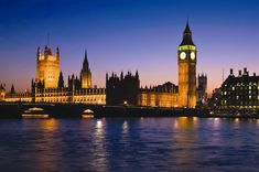 the big ben clock tower towering over the city of london at night with lights on