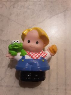 a small toy with a frog on it's back and a man holding a frog in his arms