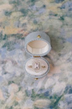 Introducing the Georgian Ring Box, a stunning homage to the classic Georgian design. Inspired by tradition, this oval-shaped beauty features an exterior crafted from fine linen, exuding timeless elegance. Open it to reveal a luxurious velvet cushion, meticulously designed to put all of the attention on your ring. Completed with a delicate metal clasp, this heirloom-worthy ring box adds a touch of sophistication to any wedding flat lay. With a capacity to hold up to a size 8 ring, it's perfect fo Pretty Ring Boxes, Vintage Ring Boxes Antiques, Engagement Ring Box Ideas, Ring Box Aesthetic, Blue Wedding Aesthetic, Unique Engagement Ring Box, Engagement Ring Boxes, Jewelry Poster, Engagement Proposal Ideas