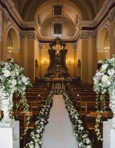 the aisle is decorated with white flowers and greenery for an elegant wedding at st mary's church