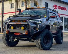 a large gray truck parked in front of a toyota dealership