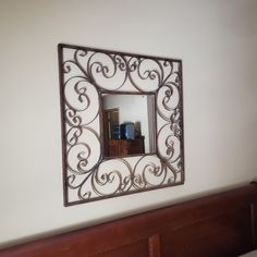 a mirror hanging on the wall above a bed