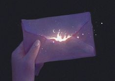 a hand holding an envelope with a glowing fire in the middle and stars on it